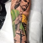 Colored San Judas and cross forearm tattoo