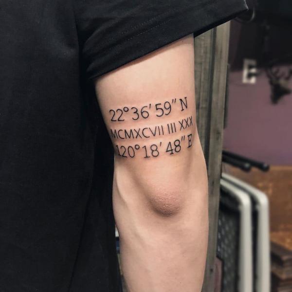 Compass and roman numerals and coordinates tattoo above elbow