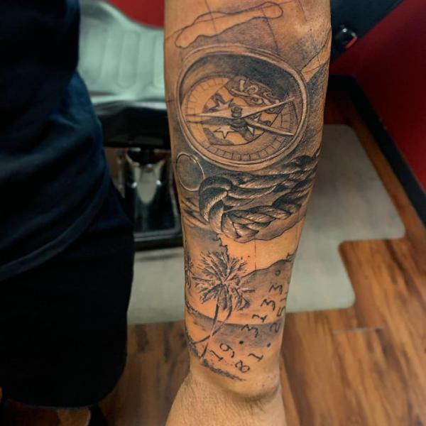 Compass and rope on map with coordinates tattoo