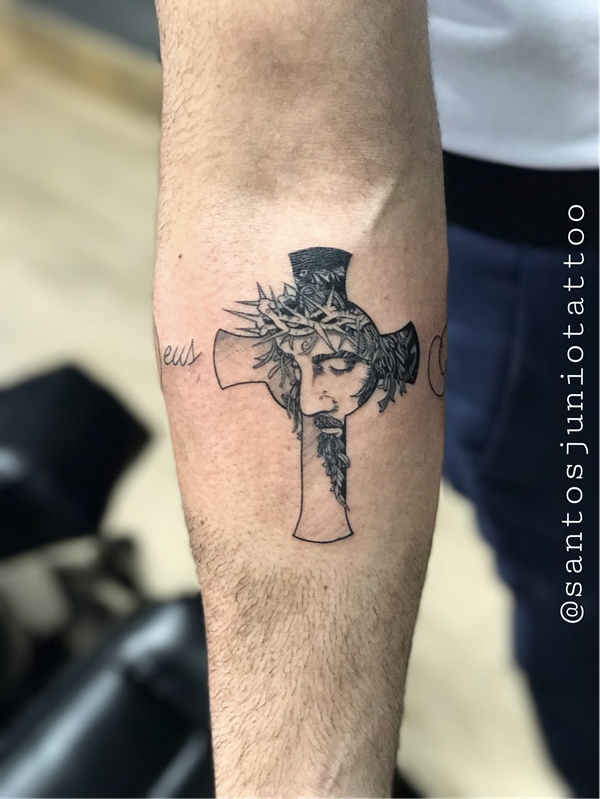 Cross and Jesus face with thorns tattoo on inner forearm