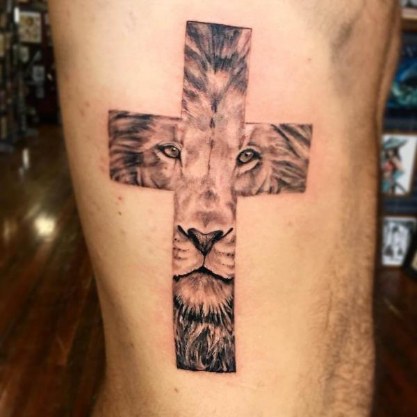 Cross with lion face side tattoo