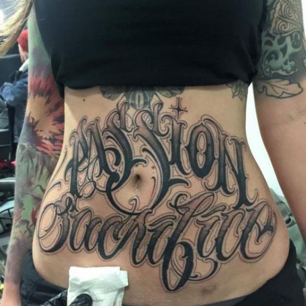 Cursive font lettering stomach tattoo