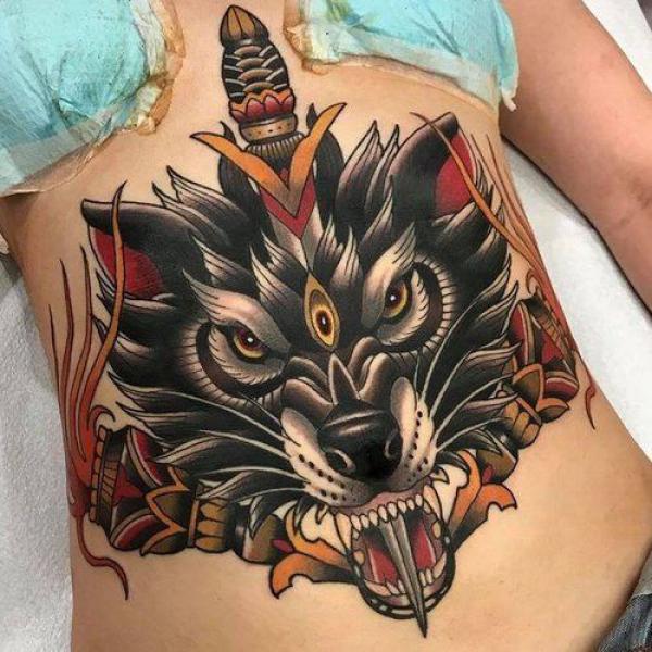 Dagger through wolf stomach tattoo