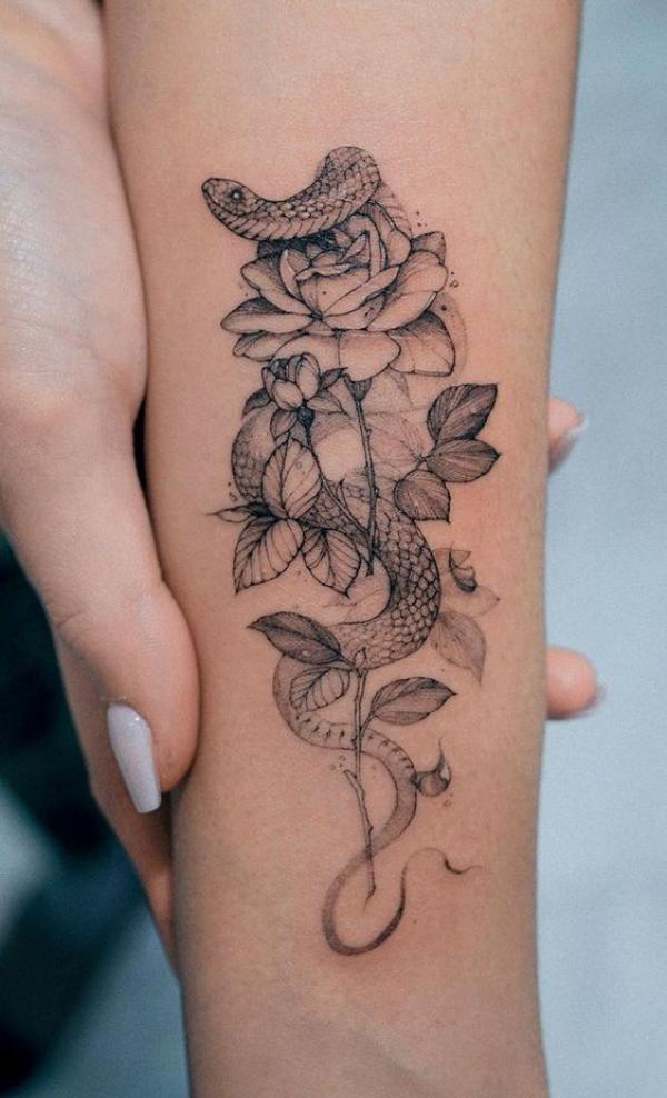 Dainty rose and snake tattoo forearm