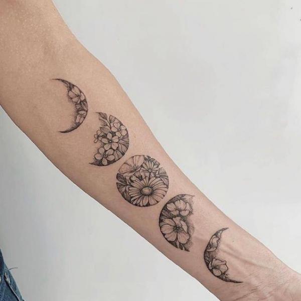 Daisy flowers Moon phases forearm tattoo