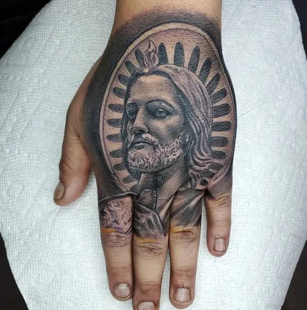 Dark San Judas portrait hand tattoo