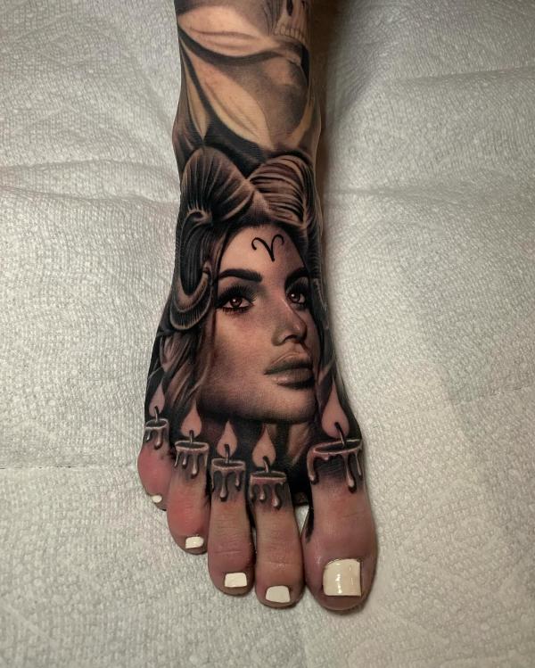 Female with Aries Ram horns glyph and candles foot tattoo realistic