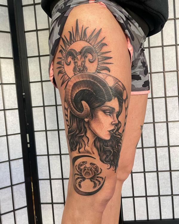 Female with Aries ram and cancer crab thigh tattoo