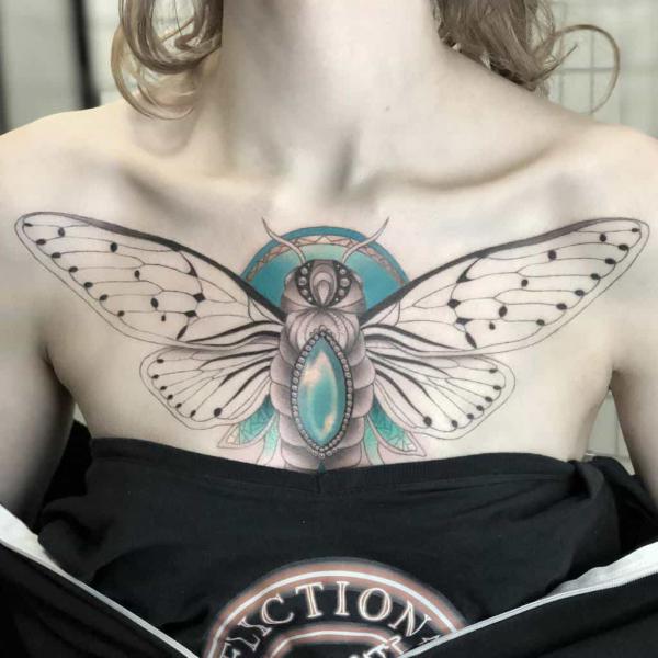 Femine cicada with dianond chest tattoo