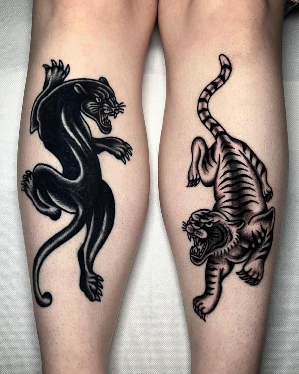 Fighting panthe and tiger tattoo on calfs