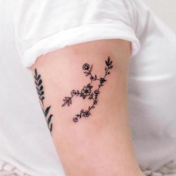 Floral Virgo constellation upper arm tattoo