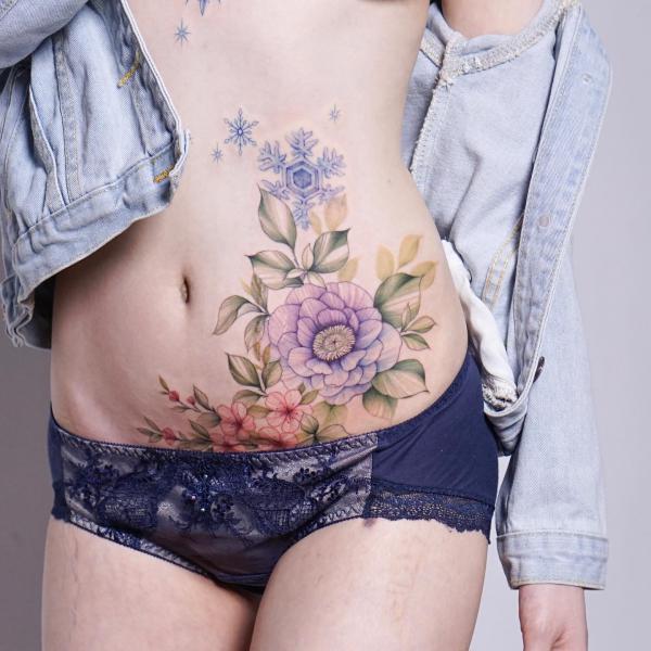 Flower and snowflake belly tattoo