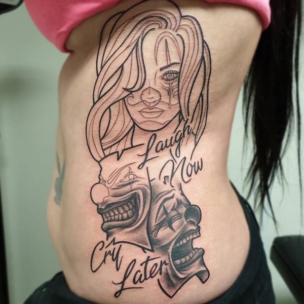 Girl with Laugh Now Cry Later masks rib cage tattoo