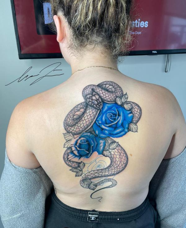 Greyscale snake and blue rose tattoo on back