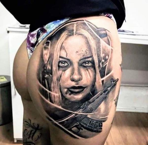 Harley quinn face and gun hip tattoo