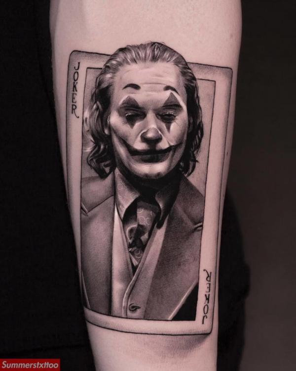 Joaquin Phoenix joker card tattoo on forearm