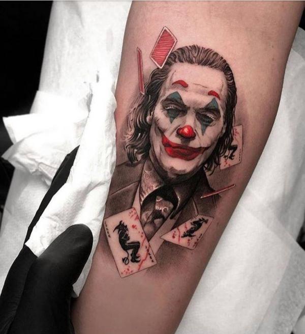 Joaquin Phoenix joker with cards forearm tattoo