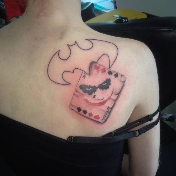 Joker card with bat outline shoulder blade tattoo