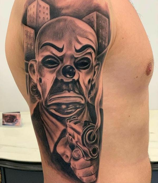 Joker clown with gun tattoo sleeve