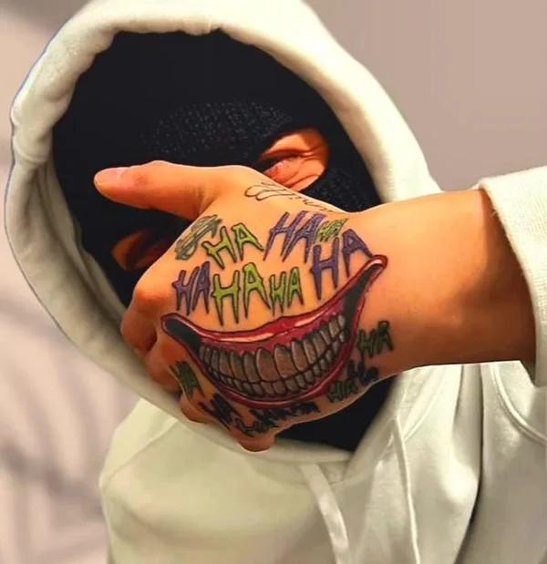Joker smile teeth tattoo with word hahaha