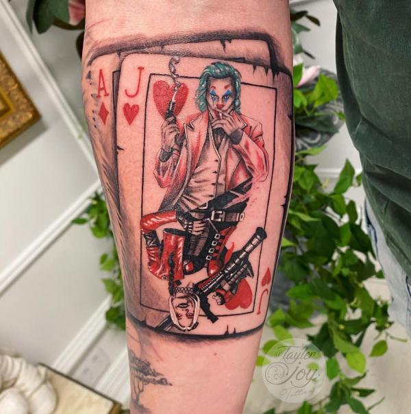 Joker with gun card forearm tattoo