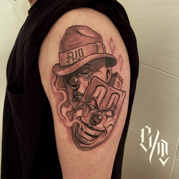 Laugh mask and Cry face upper arm tattoo