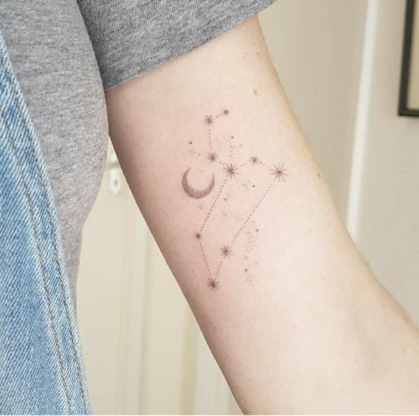 Leo constellation with moon and stars tattoo on upper arm