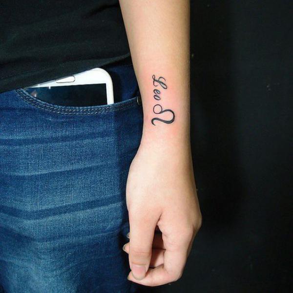 Leo glyph and lettering wrist tattoo