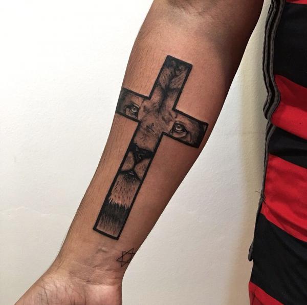 Lion face cross forearm tattoo