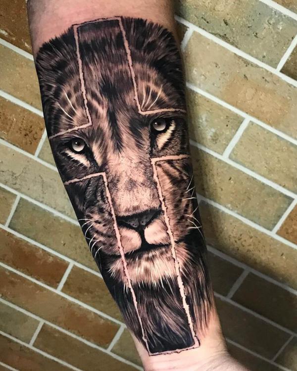 Lion face with cross tattoo