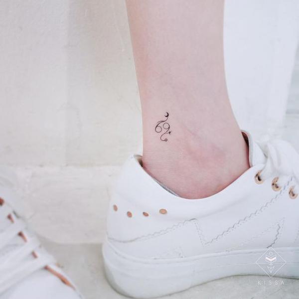 Minimalist Zodiac cancer sign ankle tattoo.