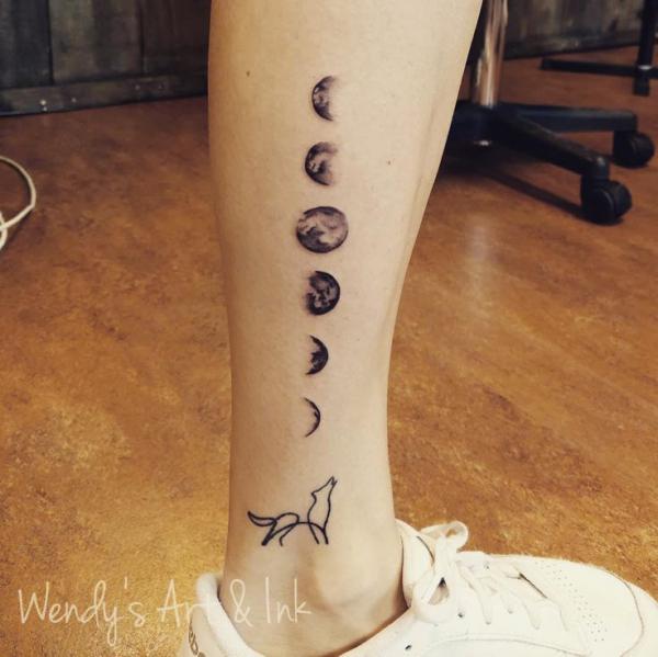Moon phases and howling wolf line work tattoo