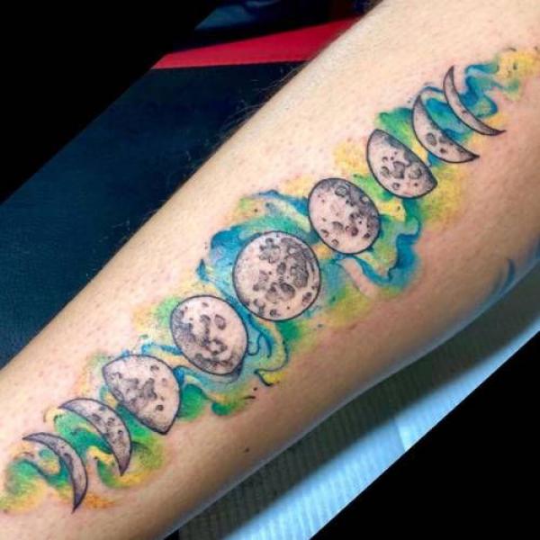 Moon phases on watercolor backdrop tattoo