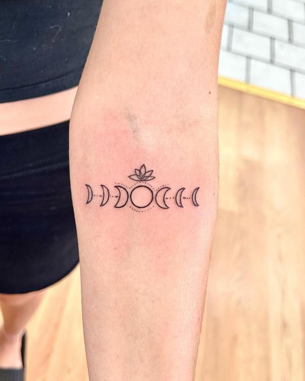 Moon phases outline tattoo below inner elbow