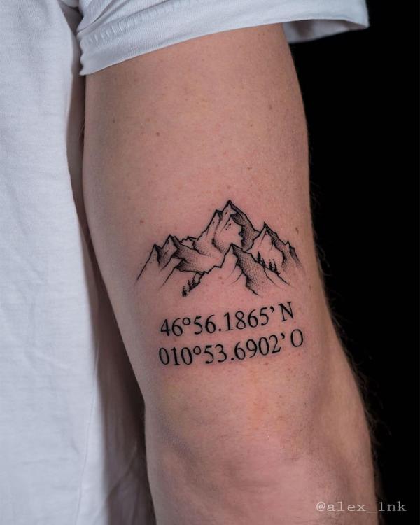 Mountain with coordinates tattoo above elbow