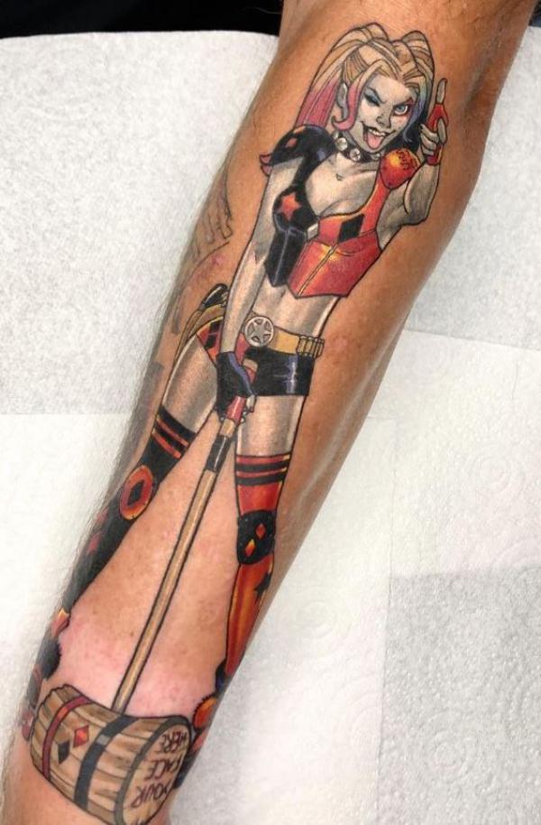 Pinup Harley Quinn with a mallet tattoo forearm