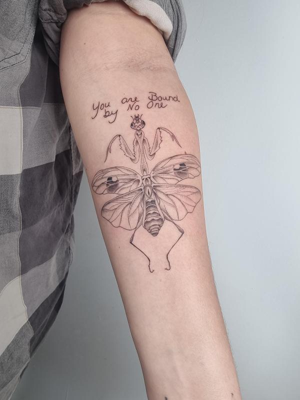 Praying mantis tattoo with phrases You are bound by No One