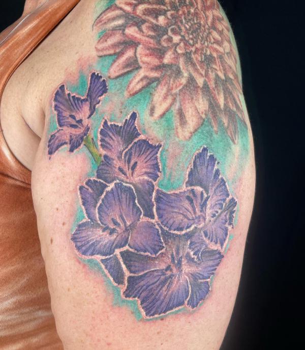 Purple gladiolus flower upper arm tattoo