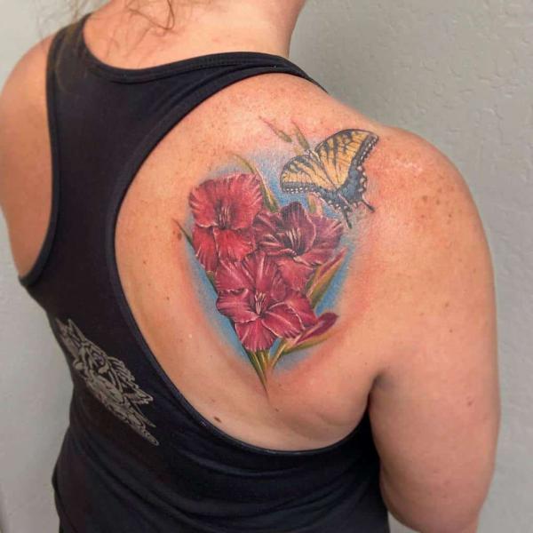 Realistic Gladiolus and butterfly tattoo on shoulder blade