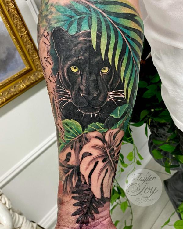 Realistic black panther with leaves tattoo