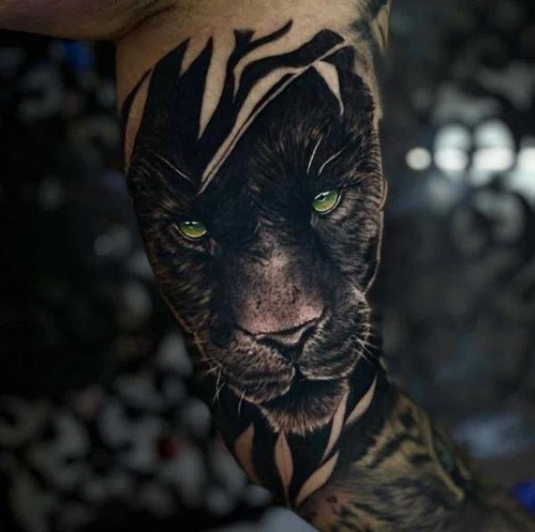 Realistic panther head bicep tattoo