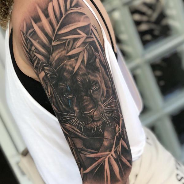 Realistic panther with leaves half sleeve tattoo