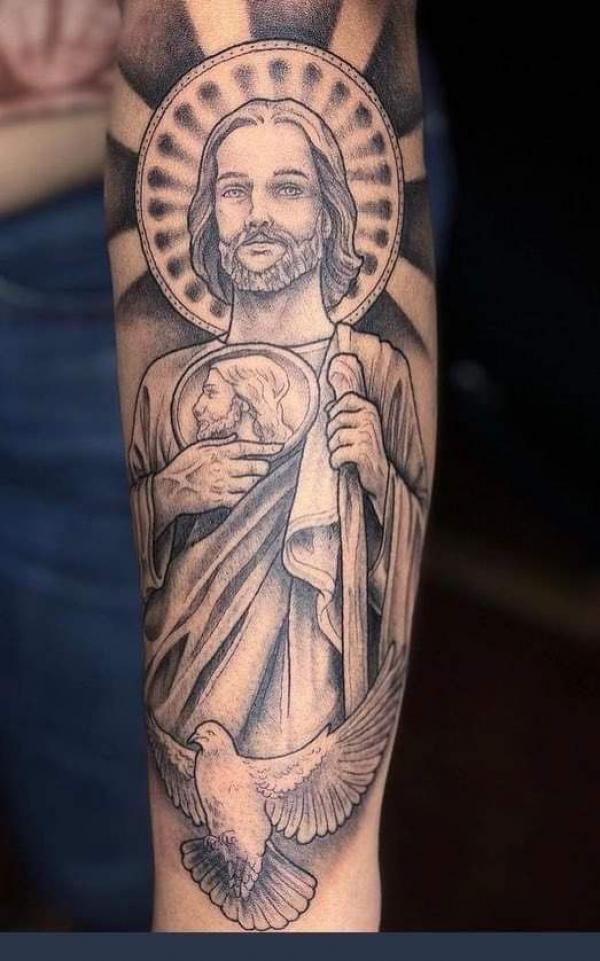 San Judas and dove tattoo on forearm