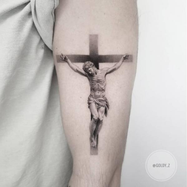 Simple cross upper arm tattoo with jesus
