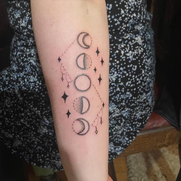 Simple moon phase tattoo on forearm