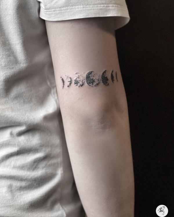 Small Moon phases tattoo above elbow