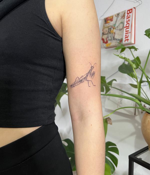 Small praying mantis upper arm tattoo