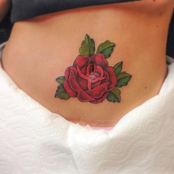 Small red rose stomach tattoo