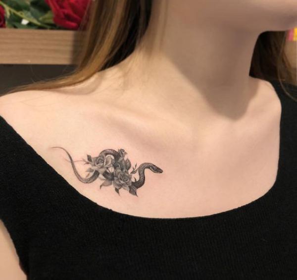 Small rose and snake clavicle tattoo