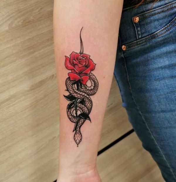 Small snake and red rose tattoo on forearm